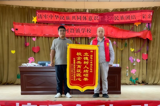 图为学校为风电场赠送锦旗 图为学校为风电场赠送锦旗